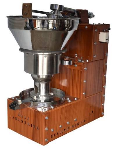 Wood bodied cold press oil machine with a stainless steel feeding hopper and collection bowl